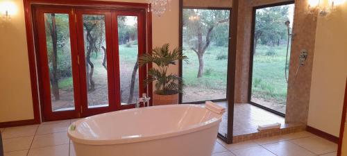 a large bathroom with a tub and a window at PHAKELA PRIVATE LODGE in Thabazimbi