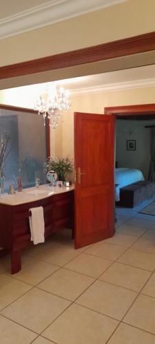 a bathroom with a tub and a sink and a bed at PHAKELA PRIVATE LODGE in Thabazimbi
