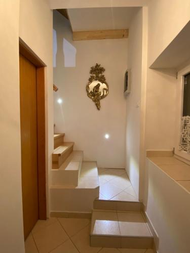 a hallway with stairs and a clock on the wall at Guesthouse Riba in Vrsar