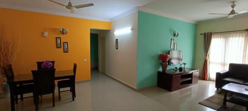 a living room with a table and a couch at Bulande Comforts-Service Apartment In Brookfield in Bangalore