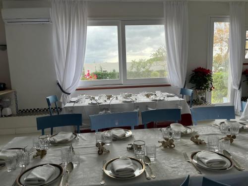 a dining room with a table with plates and glasses at Casa Azzurra in Messina