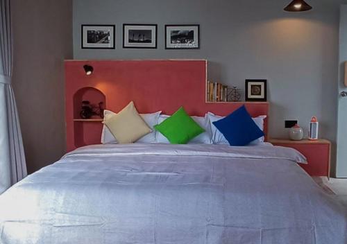 1 dormitorio con 1 cama grande y almohadas coloridas en The Oak Retreat Lamahatta, en Darjeeling