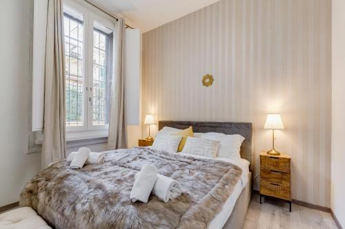 a bedroom with a large bed and two windows at Jmartins Colosseo Suites in Rome