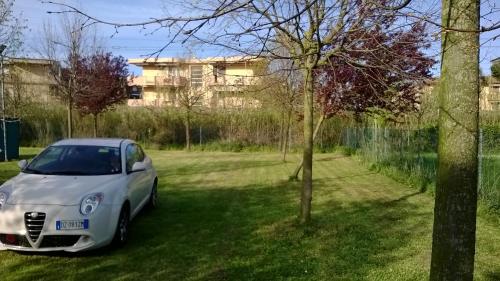 Ein weißes Auto, das auf dem Rasen im Hof geparkt ist. in der Unterkunft Hotel Rosati in Rimini