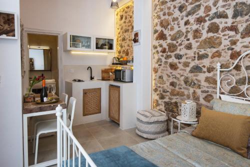 a kitchen and a living room with a stone wall at Athena Luxury Studios in Athens