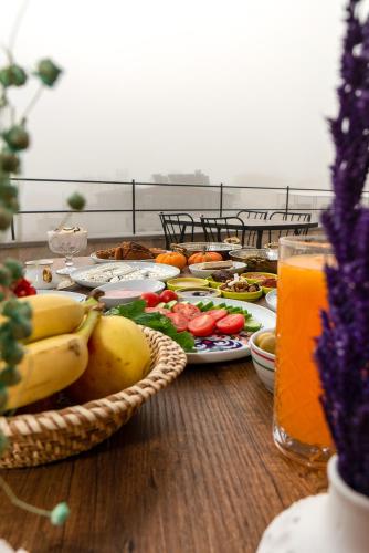ein Tisch mit Tellern voller Essen und einem Glas Orangensaft in der Unterkunft Serene Premium Stone House in Nevşehir