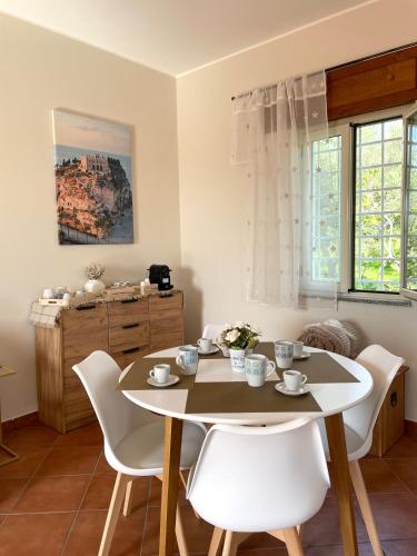 a dining room with a table and white chairs at La casa di Isa in Lamezia Terme