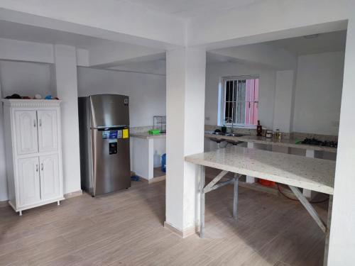 a kitchen with a stainless steel refrigerator and a table at Samana house in Santa Bárbara de Samaná