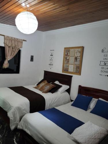 a bedroom with two beds and a chandelier at Casa de Mármol in Riobamba