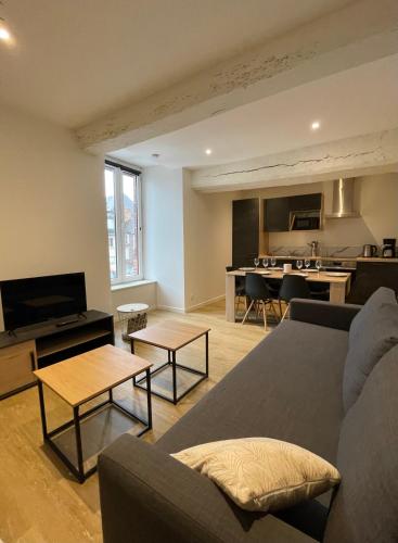 un salon avec un canapé et une cuisine dans l'établissement Gîtes de Cohuta, à Montfort-sur-Meu