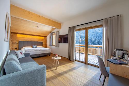 a hotel room with a bed and a large window at Boutique Hotel Schraemli's Lengmatta in Davos
