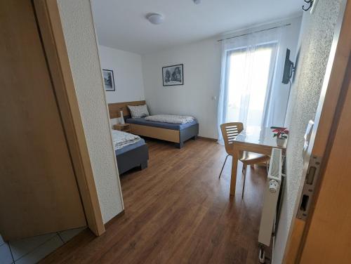 una sala de estar con una cama y una habitación con una mesa. en Pension Victoria, en Steinmauern