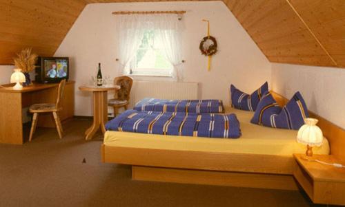 Un dormitorio con una cama con almohadas azules y una ventana en Gaststätte & Pension Alte Mühle, en Dorfchemnitz