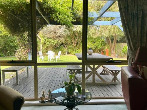 a view of a deck with a table and chairs through a window at Family Holiday Home in Inverloch