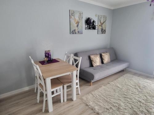 uma sala de estar com uma mesa e um sofá em Apartament Twoja Chwila em Stronie Śląskie