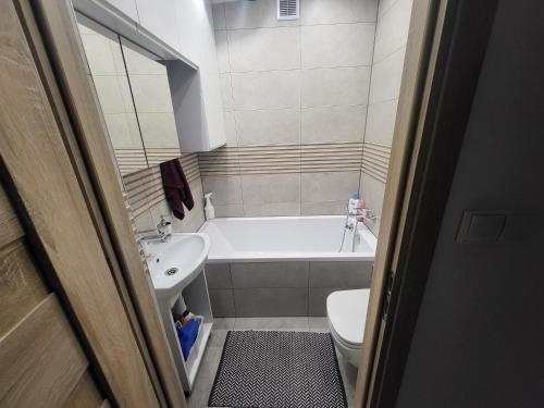 uma casa de banho com uma banheira, um lavatório e um WC. em Apartament Twoja Chwila em Stronie Śląskie