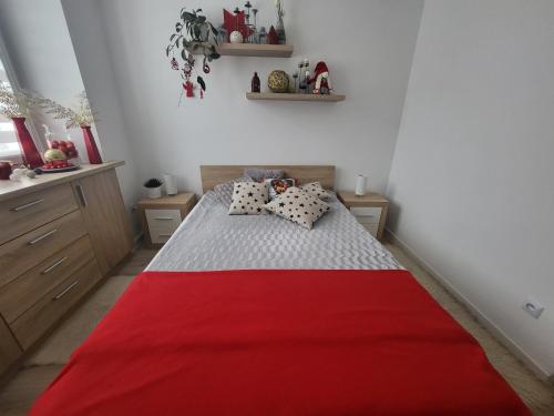 1 dormitorio con 1 cama con manta roja en Apartament Twoja Chwila, en Stronie Śląskie