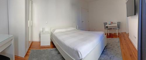 a white bedroom with a bed and a table at Museum House in Funchal