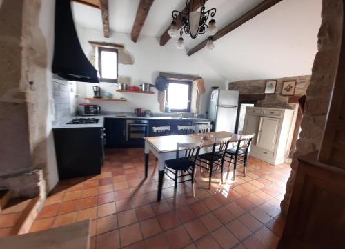 une cuisine avec une table et des chaises dans une cuisine dans l'établissement Belle Longere de 10 couchages - lac de vassiviere, à Beaumont