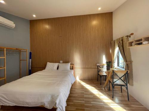 a bedroom with a bed and a table and a window at Pleiku Homestay in Pleiku