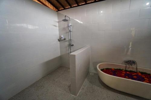 a white bathroom with a tub and a shower at Adil Villa & Resort in Ubud