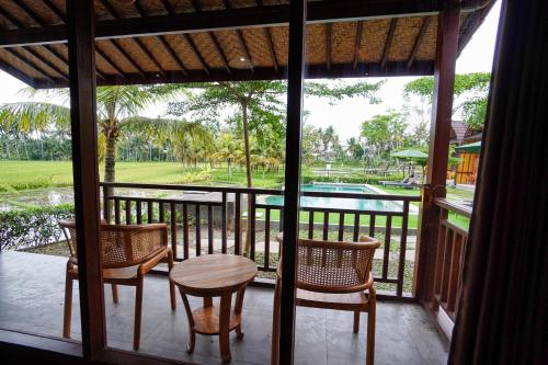 a porch with a table and chairs and a pool at Adil Villa & Resort in Ubud