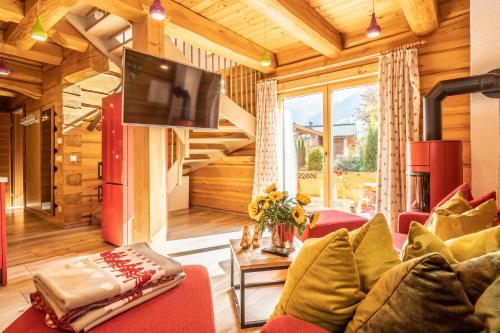 a living room with a red couch and a tv at The Kaprun Edition - Luxury Chalets & Style Suites in Kaprun