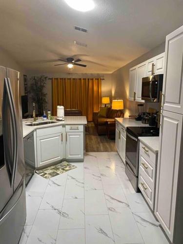 a kitchen with white appliances and a living room at Florida Suburban Oasis ~ Lk Mary/Sanford Florida! in Sanford