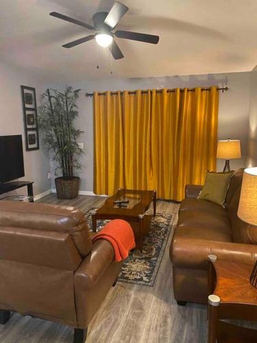 a living room with a couch and a ceiling fan at Florida Suburban Oasis ~ Lk Mary/Sanford Florida! in Sanford