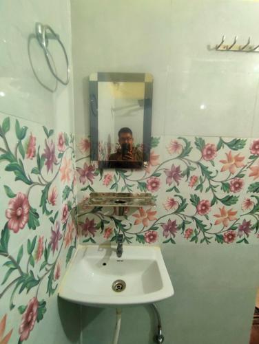 a man taking a picture of a sink in a bathroom at Anandam Home Stay in Rishīkesh