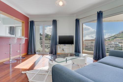 a living room with a couch and a tv at Camara de Lobos Duplex Apartment by Holiday Rental Madeira in Câmara de Lobos