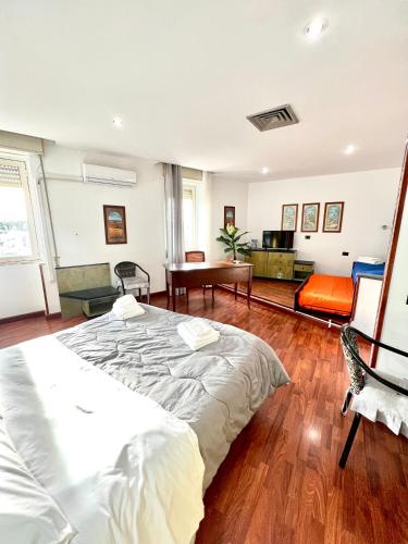 a bedroom with a large bed and a living room at Hotel Como in Siracusa