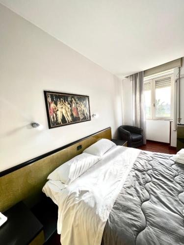 a bedroom with a bed and a painting on the wall at Hotel Como in Siracusa