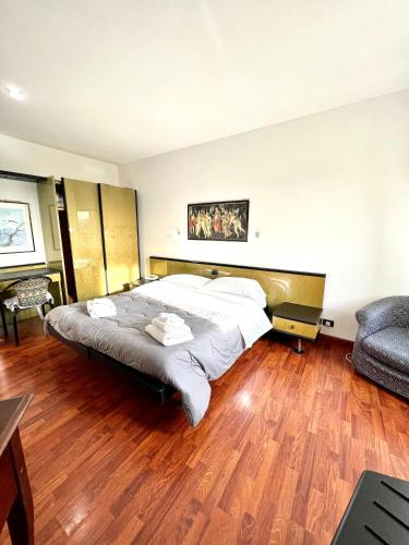 a bedroom with a large bed and a couch at Hotel Como in Siracusa