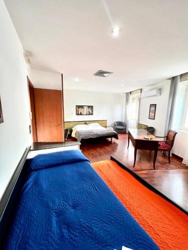 a bedroom with a bed and a large blue rug at Hotel Como in Siracusa