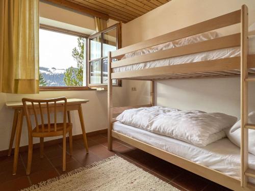 a bedroom with bunk beds and a table and a chair at Chalet Horn by Apartment Managers in Kitzbühel