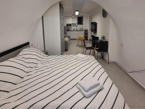 ein großes weißes Bett mit zwei weißen Handtüchern darauf in der Unterkunft Jaffa 17 - urban loft in Jerusalem