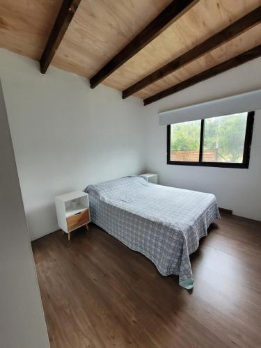Habitación blanca con cama y ventana en Calma Nativa, en Maldonado