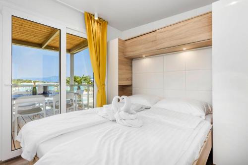 two white swans sitting on a bed in a bedroom at Mobile Homes in Camping Omisalj, island Krk, with swimmingpool in Omišalj