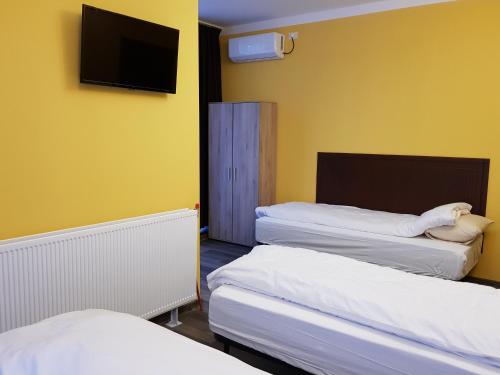 Habitación con 2 camas y TV de pantalla plana. en Hotel Restaurant La Passione, en Tecuci