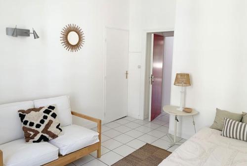 a living room with a white couch and a table at Maison de ville confortable avec piscine in Pons