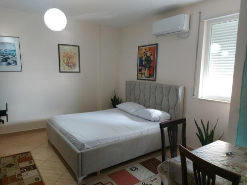 a bedroom with a bed and a table in it at Bral Apartments 4 in Durrës