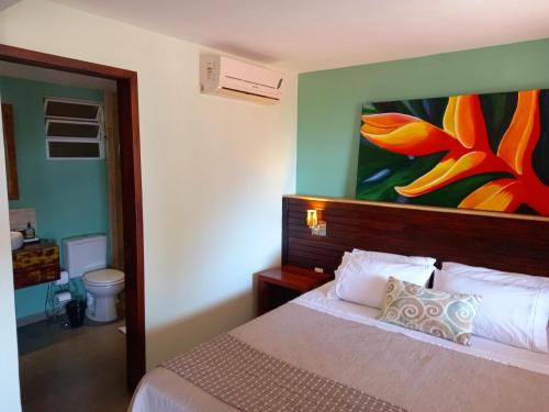 a bedroom with a bed with a painting on the wall at Casa Verde Río in Rio de Janeiro