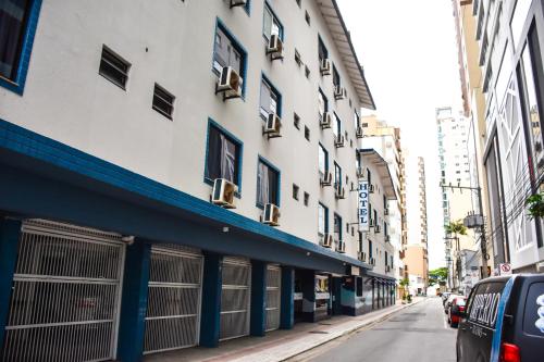 een gebouw in een straat waar auto's voor geparkeerd staan bij Sandri City Hotel in Balneário Camboriú