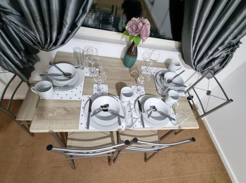 uma mesa com pratos e copos de vinho em *F1*5GH* Setup for your most relaxed & amazing stay + Free Parking + Free Fast WiFi * em Leeds