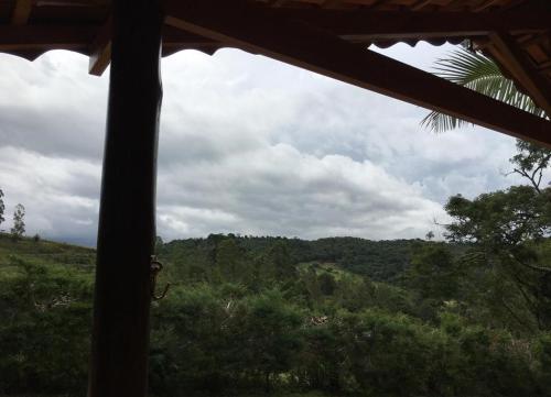 a view of a forest from a house window at Estância Liberdade in Santo Antônio do Pinhal