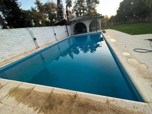 una gran piscina azul en el patio trasero en Amplia casa Paso de la Patria en Paso de la Patria