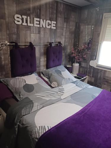 - une chambre avec un grand lit et un panneau incliné sur le mur dans l'établissement Chalet de charme avec piscine, au Castellet