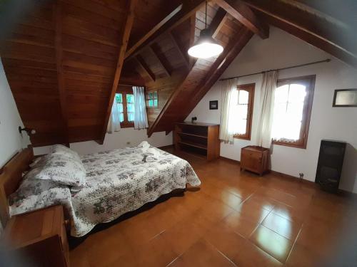 a bedroom with a bed and wooden floors and windows at Casa de Huéspedes Silvana in San Martín de los Andes