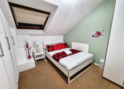 a small bedroom with a bed with red pillows at *F1*5GH* Setup for your most relaxed & amazing stay + Free Parking + Free Fast WiFi * in Leeds